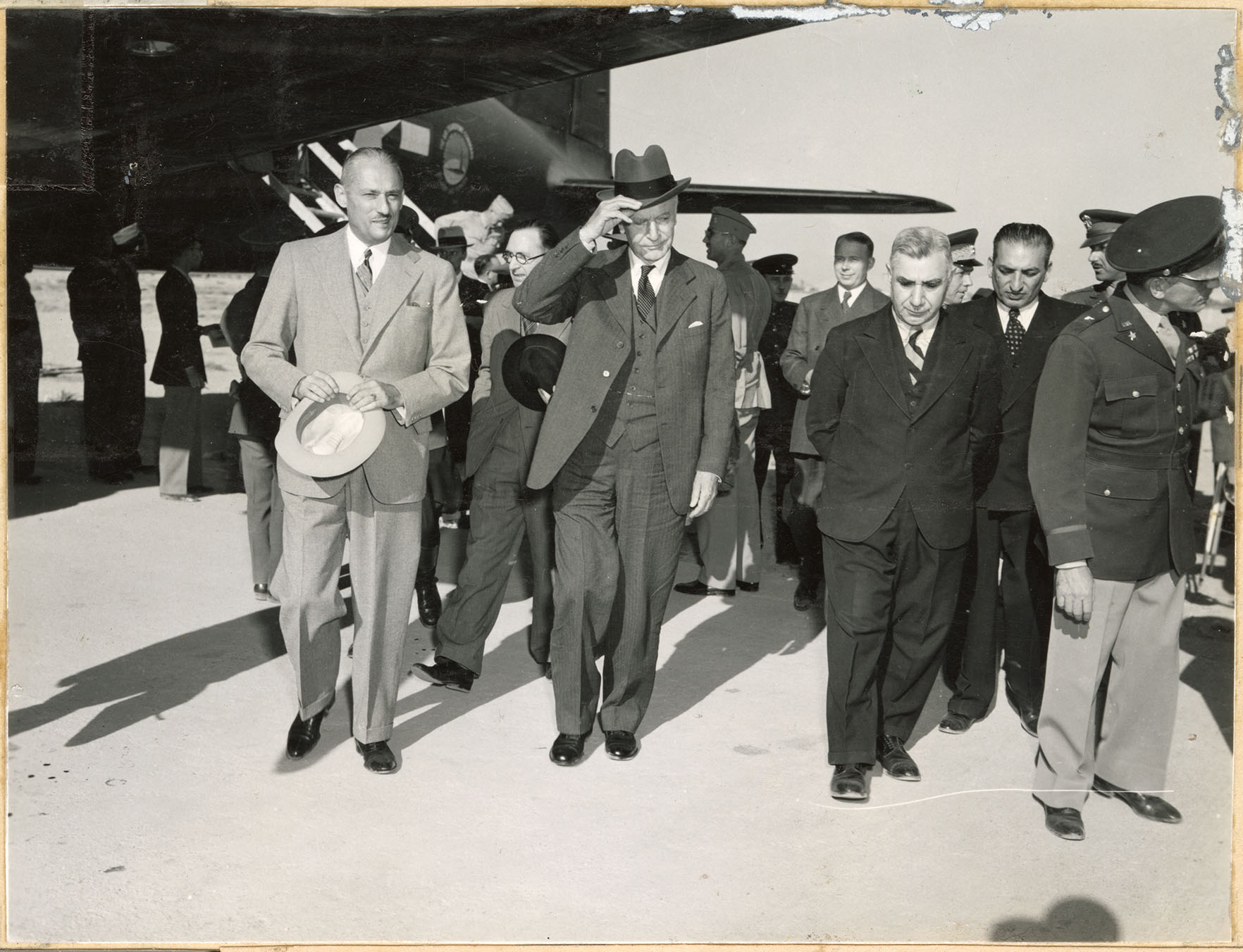 A group of civilian men walk away after exiting an airplane
